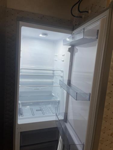 an empty refrigerator with its door open and empty shelves at Rachid in Oulad Akkou