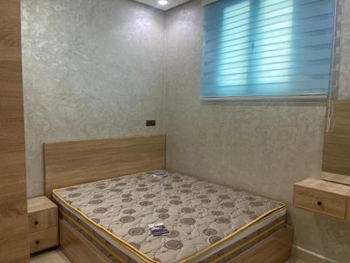 a small bed in a room with a window at Rachid in Oulad Akkou