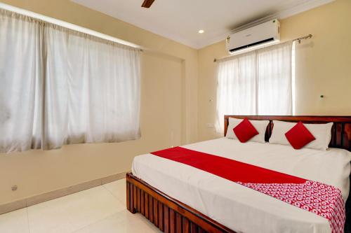 a bedroom with a large bed with red pillows at Hotel O RD CONVENTIONS in Visakhapatnam