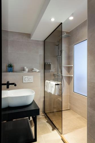 a bathroom with a sink and a shower at Hotel Grand Asia in Walferdange