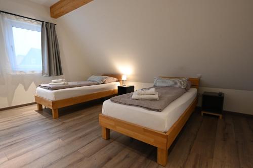 two twin beds in a room with a window at Guesthouse-Coburg 1 in Großheirath