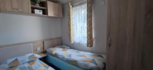 a small bedroom with two beds and a window at Billing Aquadrome ,2 bedrooms, Royale Poplar KM 12 in Great Billing