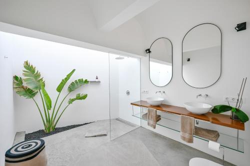 a bathroom with two sinks and two mirrors at Casa Alisios Sea View Villa private Infinity Pool Sunsets in La Pared