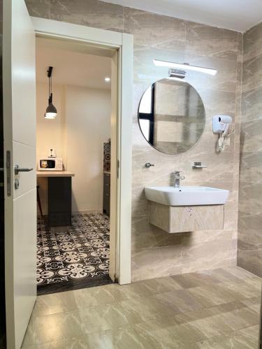 a bathroom with a sink and a mirror at Zemilo Hotel Apartment in Addis Ababa