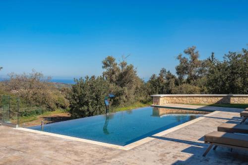 a swimming pool in the middle of a patio at Sunny Villa-Earthen Stone Gem by etouri in Margarítai