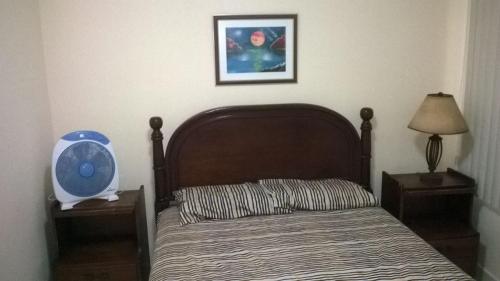 a bedroom with a bed with a wooden head board at Departamento Torresol Tropical in Tonsupa