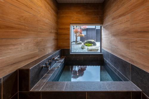 a bathroom with a large pool in the middle of the room at Anto Azumino in Azumino