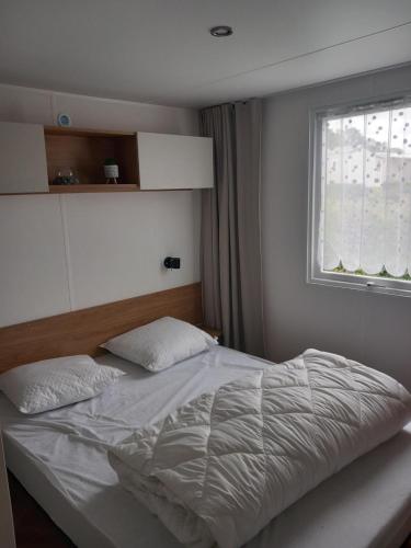 a bed in a bedroom with a window at L'échapée verte in Litteau