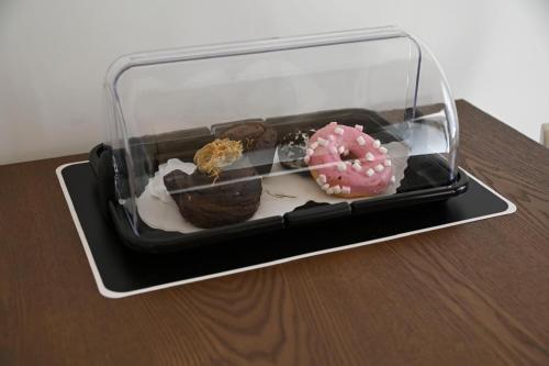 a glass container with different types of donuts on a table at DreamHouse in Bari