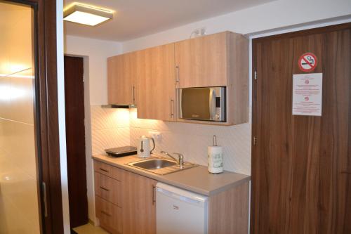a small kitchen with a sink and a microwave at Kalinowy Sen in Warsaw