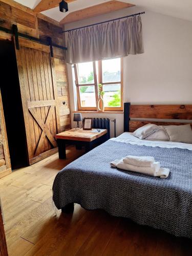 een slaapkamer met een bed, een raam en een tafel bij MX Pokoje in Lipno