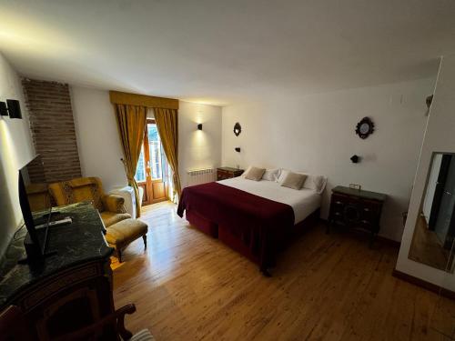 a bedroom with a bed and a living room at Hotel Rural Cayetana in Piedrahita