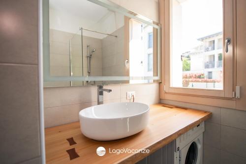 a bathroom with a large white sink on a wooden counter at Garda Nest in Padenghe sul Garda