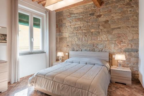 a bedroom with a stone wall and a large bed at Casa Loretta Vicopisano in Vicopisano