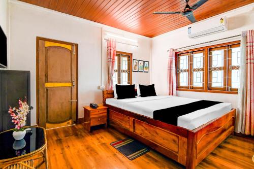 a bedroom with a large bed and a television at Super Hotel O Chilapata Forest Formerly Moner Manush Homestay in Uttar Simlabari