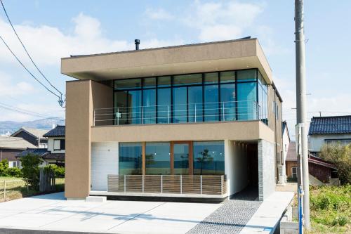a house with large glass windows on a street at Guest Villa on the BI-CHI in Sado