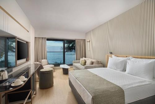 ein Hotelzimmer mit einem großen Bett und einem Fernseher in der Unterkunft Waveside hotel in Altınordu