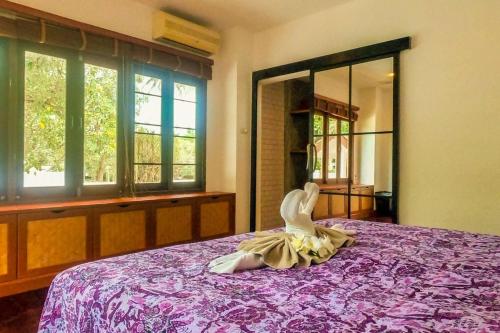 a woman in a dress sitting on a bed at Southern Lanta B9 in Ko Lanta