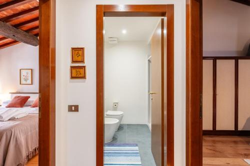 a bedroom with a bed and a bathroom with a toilet at Mordini Loft - 3 Bedrooms - Lucca in Lucca