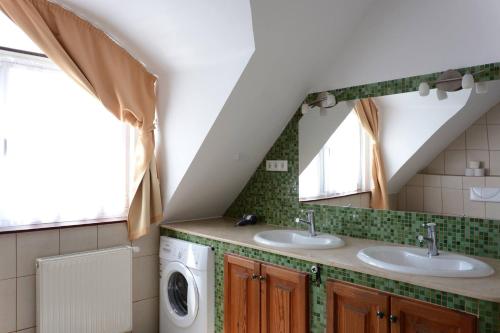 a bathroom with two sinks and a washer and dryer at Forrás Ház Tapolca in Tapolca