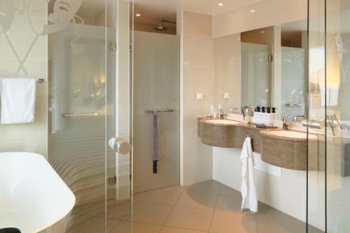 a bathroom with two sinks and a glass shower at Scandic Neptun in Bergen