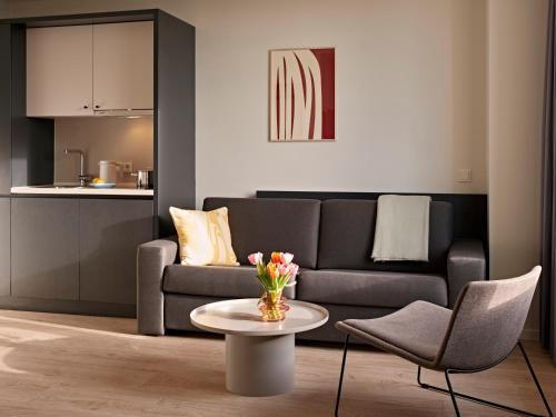 a living room with a couch and a table at Numa Cologne Ehrenfeld in Cologne