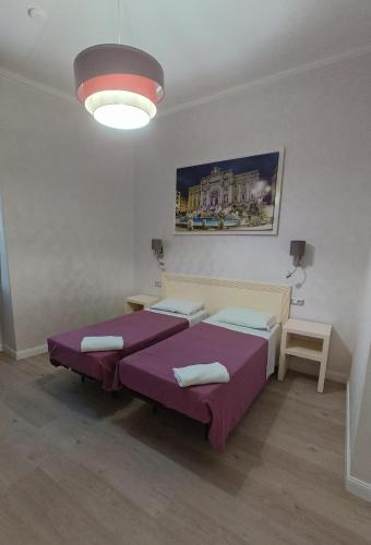 a room with two beds and a large light at Hotel PRINCIPE AMEDEO in Rome