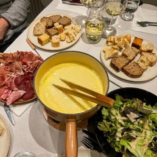 a table with a bowl of soup and plates of food at Hôtel Chalet Sainte-Anne in Condamine-Châtelard