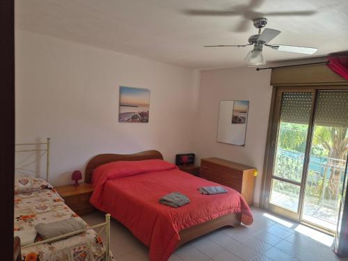 a bedroom with a red bed and a window at Villa Giù, indipendent villa near airport and sea in Cinisi