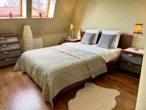 a bedroom with a large bed and two night stands at Apartament Pers - komfortowy relaks przy kominku i klimatyzacji in Szczawno-Zdrój