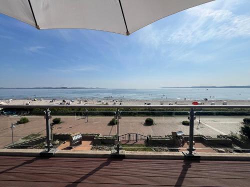 a view of a beach with benches and the ocean at Ostsee-Strandhaus-Holnis in Glücksburg