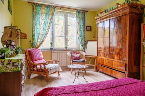 a bedroom with a bed and two chairs and a window at Gîte forestier du Moulin - 10 pers in Raon-sur-Plaine