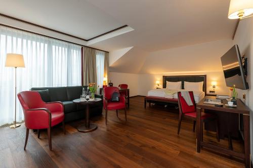 a hotel room with a bed and a living room at Bad Horn - Hotel & Spa in Horn