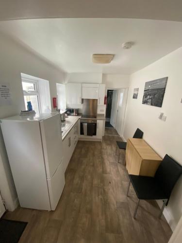 a kitchen with white appliances and a wooden floor at Rosie’s rest in Bridlington