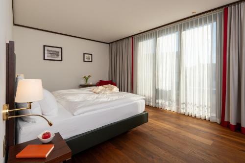 a hotel room with a bed and a large window at Bad Horn - Hotel & Spa in Horn