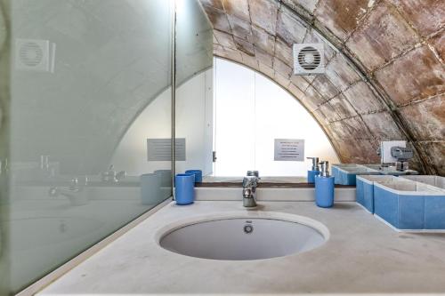 a bathroom with a sink and a large window at Loft Calella de Palafrugell in Calella de Palafrugell