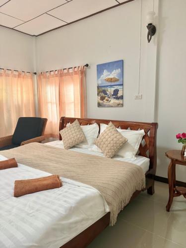 a bedroom with two beds and a chair in it at Laydee Resort in Chumphon