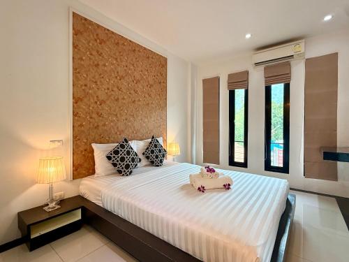 a bedroom with a large white bed with two pillows at Westkey Kamala Hotel in Kamala Beach