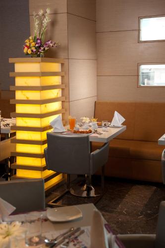 a dining room with a table and chairs and flowers at Royal Orchid Central Vadodara in Vadodara