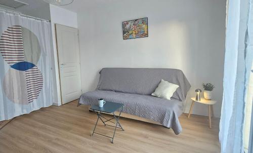 a small bedroom with a bed and a table at Studio Indépendant au calme in Cugand
