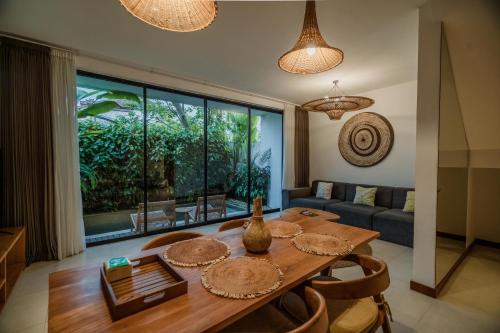 a dining room with a table and a couch at Premier Umalas Villas in Seminyak