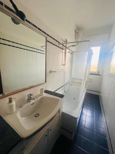 a bathroom with a sink and a tub and a mirror at Onda blu in Marina Julia