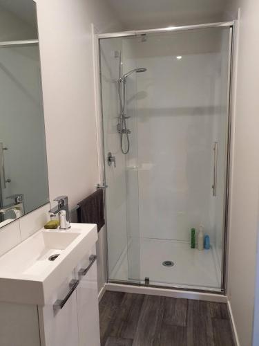 a white bathroom with a shower and a sink at Twizel getaway in Twizel