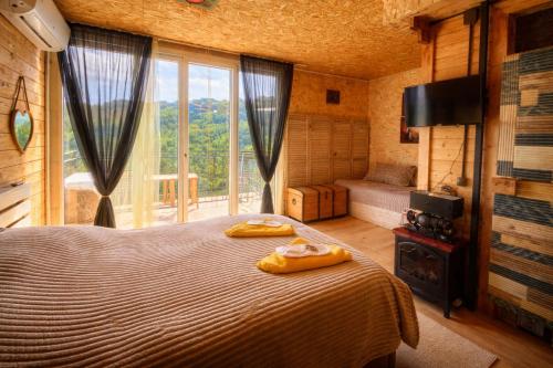 a bedroom with a large bed and a large window at Villa Provance & Swimming Pool in Sighnaghi
