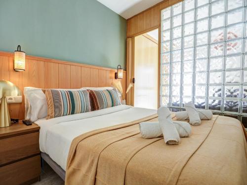 ein Schlafzimmer mit einem großen Bett und einem großen Fenster in der Unterkunft Bonaire Apartment by Hello Homes Sitges in Sitges