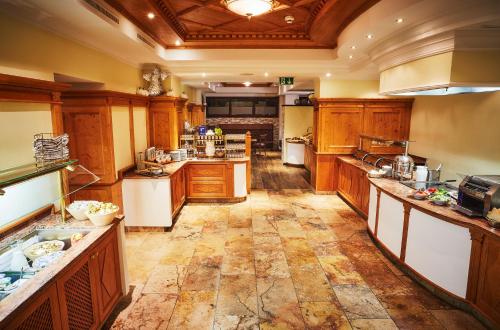 a large kitchen with wooden cabinets and white appliances at Hotel Wagrainerhof in Wagrain