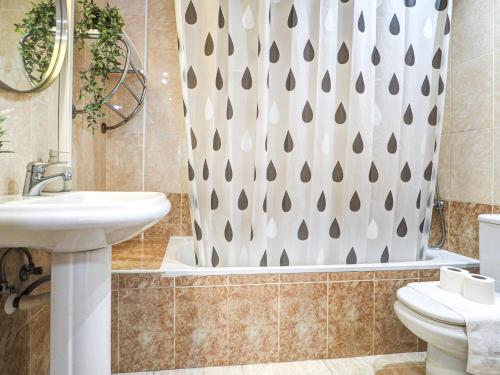 ein Badezimmer mit Waschbecken und Duschvorhang in der Unterkunft Bonaire Apartment by Hello Homes Sitges in Sitges