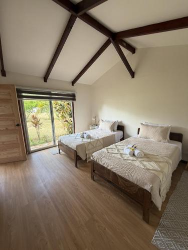 a bedroom with two beds and a large window at Cabañas Anariki in Hanga Roa