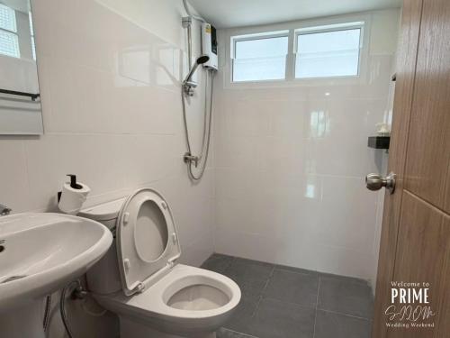 a white bathroom with a toilet and a sink at Prime Silom in Bangkok