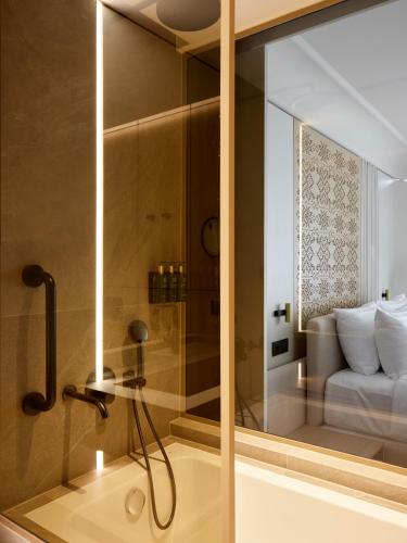 a bathroom with a shower with a glass wall at Boutique Hotel Venturo, a Member of Design Hotels in Split